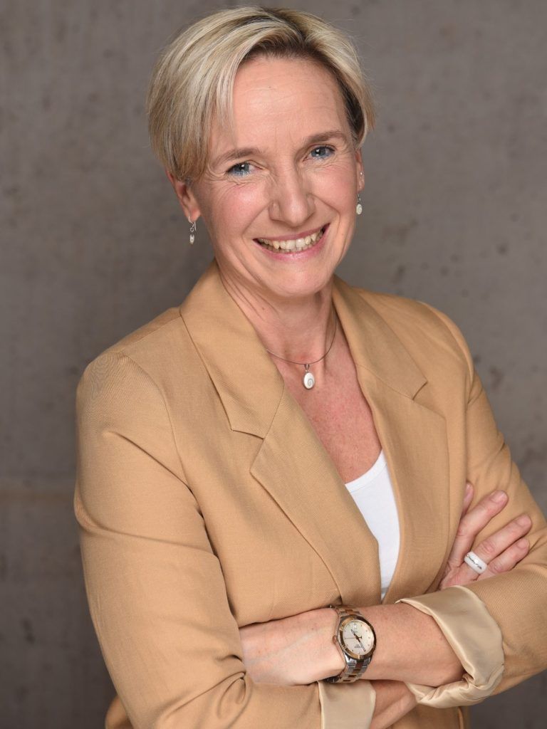 Christiane Jahner im beigen Blazer, mit verschränkten Armen