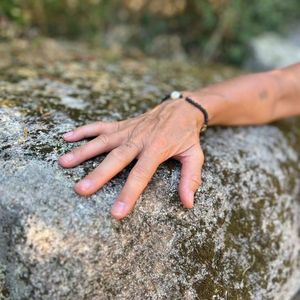Hand auf einem von Flechten bewachsenen Felsen